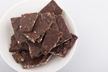 Broken chocolate chips pieces isolated on white background.