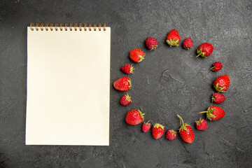 top view fresh red strawberries lined on a dark-grey background color berry fruit