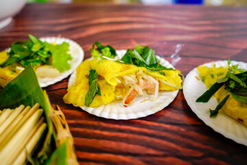 Banh xeo, Vietnamese traditional street food yellow crispy rice flour cake. Sizzling cake, named for the loud sizzling sound it makes when the rice batter is poured into the hot skillet