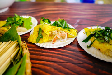 Banh xeo, Vietnamese traditional street food yellow crispy rice flour cake. Sizzling cake, named for the loud sizzling sound it makes when the rice batter is poured into the hot skillet