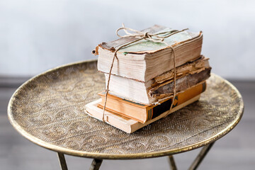 Old 100 years books on antique table closeup. History, knowledge, nostalgia, old age concept. Retro...