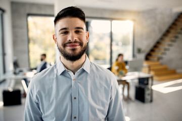 Obraz premium Portrait of young happy businessman in the office.