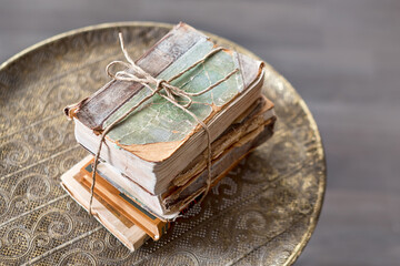 Old 100 years books on antique table closeup. History, knowledge, nostalgia, old age concept. Retro style.