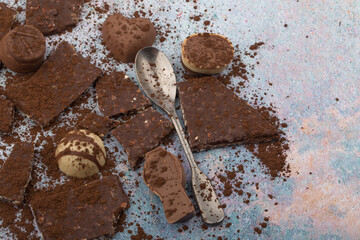 Broken almone chocolate pieces with cocoa powder.