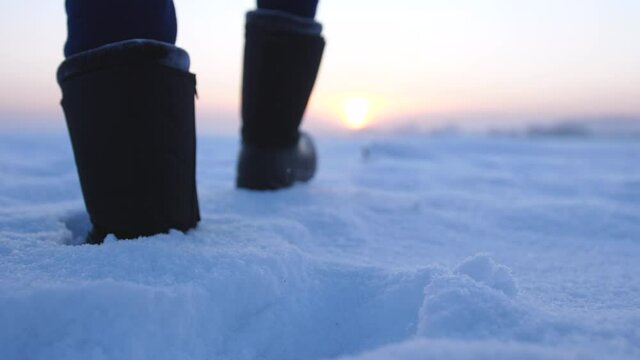 Male feet walking in deep snow. foot steps of hiker. recreational winter activity outdoors. slow motion