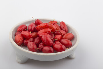Pile of fresh cornus fruit on a white background.