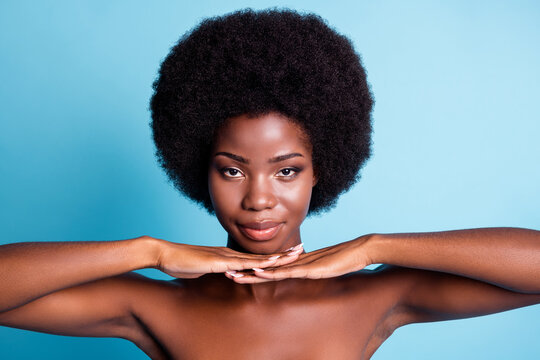 Closeup headshot photo of dark skin big volume hairstyle lovely charming woman hands chin skin health improve procedure calm glance beauty concept naked isolated blue color background