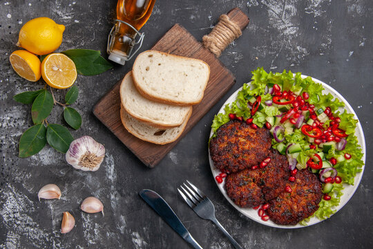 top view meat cutlets with salad and bread on grey background dish photo food meal