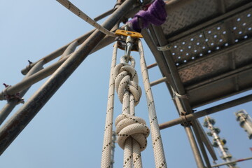 White rope with figure of eight knot into Aluminum safety harness loop equipment and pulley to...