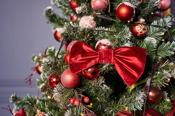 velvet red bow as a decoration on the Christmas tree, together with red balls decorates the Christmas tree