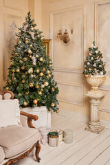 a room with light walls in which there is a beautiful Christmas tree, decorated with golden balls and ornaments
