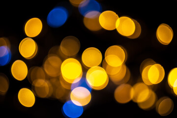 Perfect bokeh for a festive New Year and Christmas background. Defocused abstract yellow and blue light circles