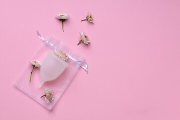 Menstrual cup with flowers on pink background