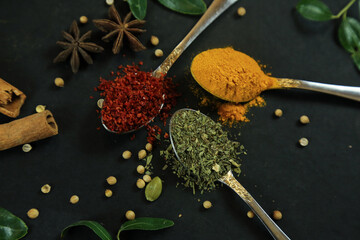 Wide variety spices and herbs on background of black table