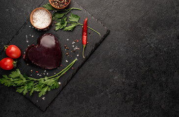 heart shaped raw liver on stone background with a copy of the space for your text.	


