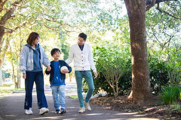 公園で仲良く散歩をする若い夫婦たち