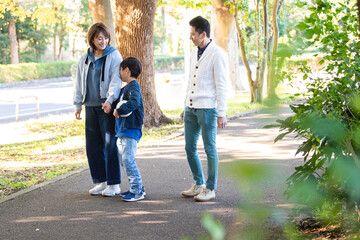 公園で仲良く散歩をする若い夫婦たち