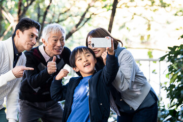 みんなで仲良く家族写真を撮っている親子とおじいちゃん