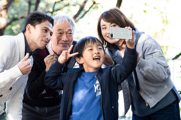 みんなで仲良く家族写真を撮っている親子とおじいちゃん