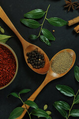 Wide variety spices and herbs on background of black table