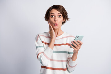 Photo of excited funny young lady wear striped sweater holding modern gadget arm cheek isolated grey color background