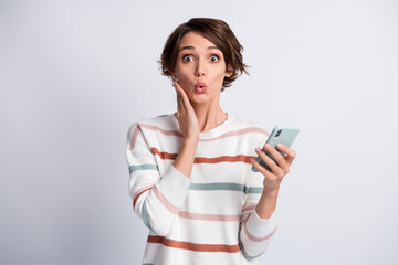 Fototapeta premium Photo of excited funny young lady wear striped sweater holding modern gadget arm cheek isolated grey color background