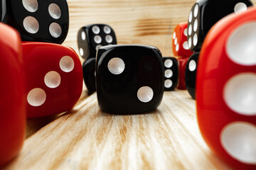Red and black dice cubes on wooden background