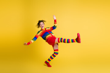 Fototapeta na wymiar Full length photo of funky lady raise leg stand on toe bending wear striped sweater short skirt knee socks shoes isolated yellow color background