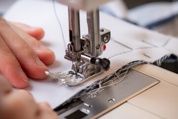 Young tailor sewing christmas decorations for children's party. Selective focus. Shallow depth of field. 