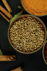 Wide variety spices and herbs on background of black table