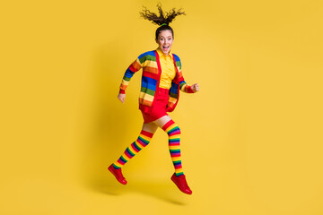 Full length body size view of pretty cheerful wavy-haired girl jumping running good mood isolated bright yellow color background