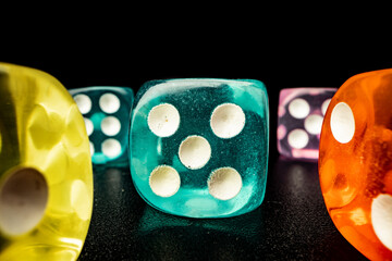 Group of playing dice cubes on black surface, macro