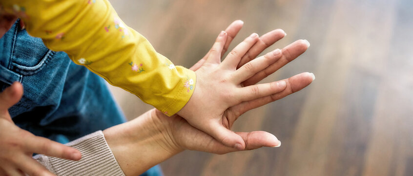 Two generations. Close up shot of grandmother opened her palm to a small granddaughters hand