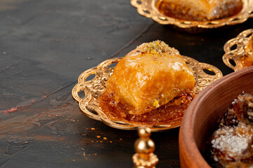 Piece of Turkish baklava in golden arabic plate