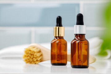 Glass cosmetic oil bottles with pipette in bathroom