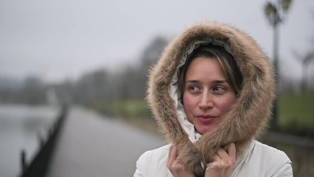Woman in white winter coat smiling in the park
