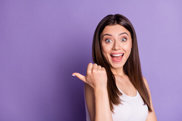 Fototapeta premium Photo of surprised funny young woman wear casual white outfit pointing thumb empty space isolated violet color background