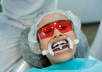 Closeup of young woman wearing mouth retractor waiting for oral examination in dentistry office.