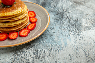 front view yummy pancakes with honey and strawberries on a light background cake fruit sweet
