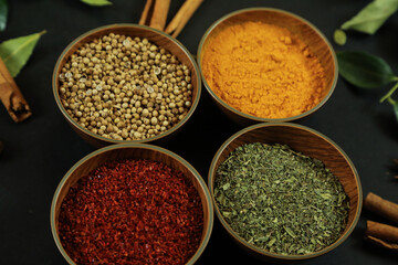 Wide variety spices and herbs on background of black table