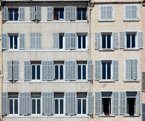 typical facade of an old hotel with open and closed shutters