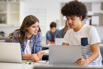 Multiethnic students studying together on laptop