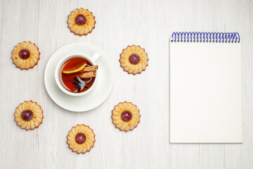 top view yummy grape cookies with cup of tea on white desk sweet dessert biscuit pie