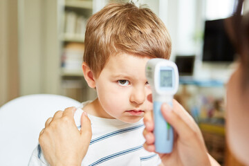 Kinderarzt beim kontaktlos Fieber messen