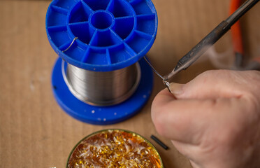 Close up of a soldering iron melts rosin