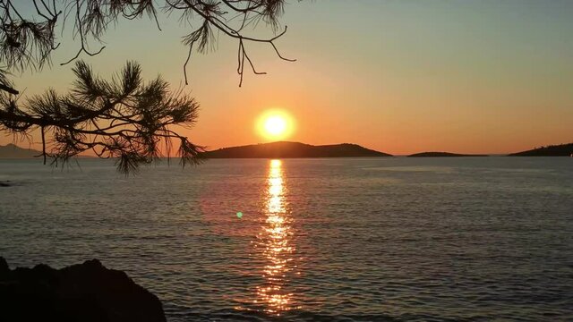 4K. Beautiful scene of sun setting over the island in time lapse mode. Cinematic timelapse video of sunset over an island in Foca, Izmir, Turkey. 