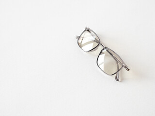 Glasses for computer and vision with a transparent frame on a white textured background.