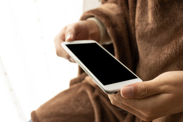 温かい恰好でスマートフォンを使う男性