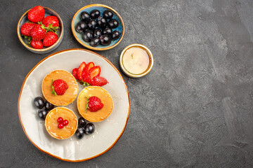 top view yummy pancakes little formed with fruits on grey background pie fruit cake