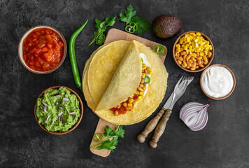 Tortilla wrap or burrito with corn, beans, greens, and homemade guacamole.